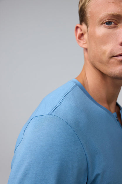 Detail shoulder view of man wearing Pima Long Sleeve Henley in Blue Heaven