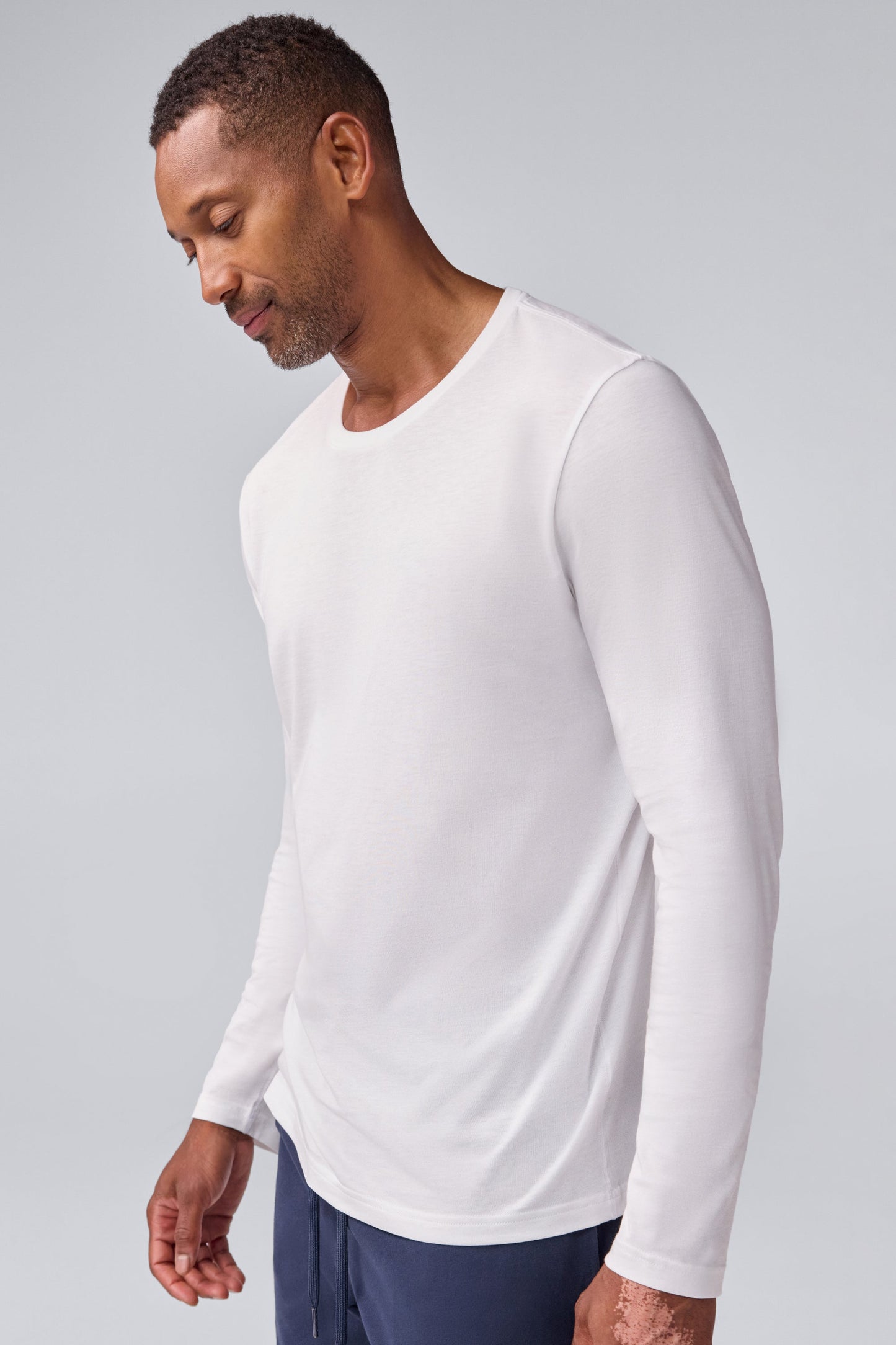 Side view of a man wearing Pima long sleeve T-shirt in Bright White
