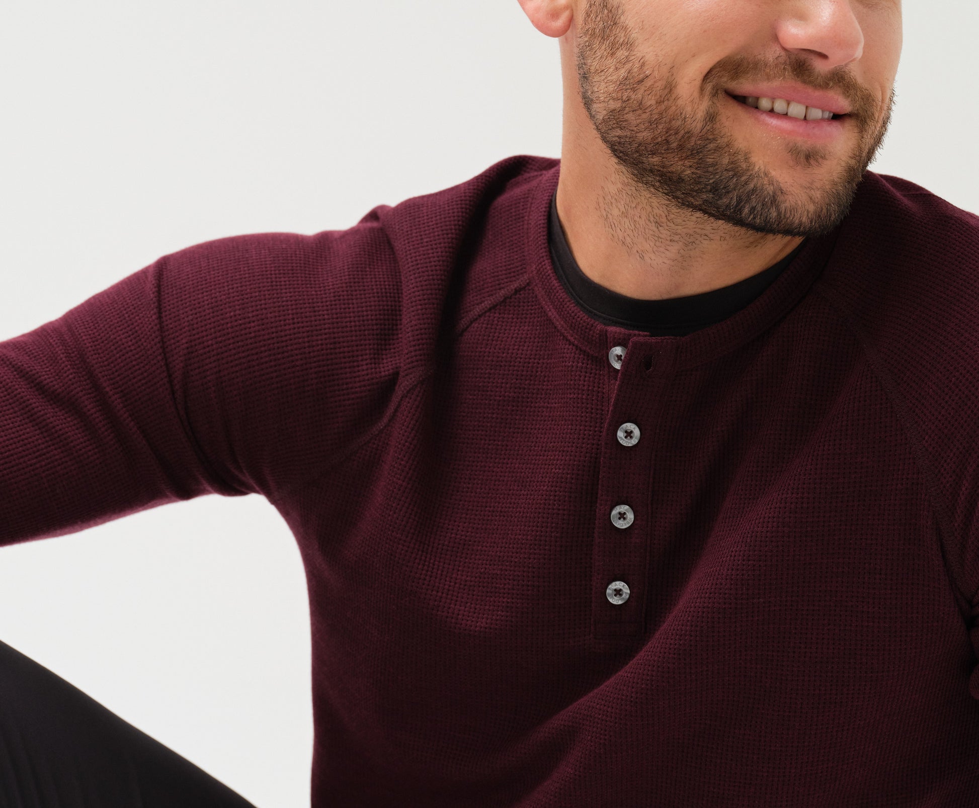 Close up front view of a man wearing WARMKNIT Waffle Henley in Lambrusco Heather